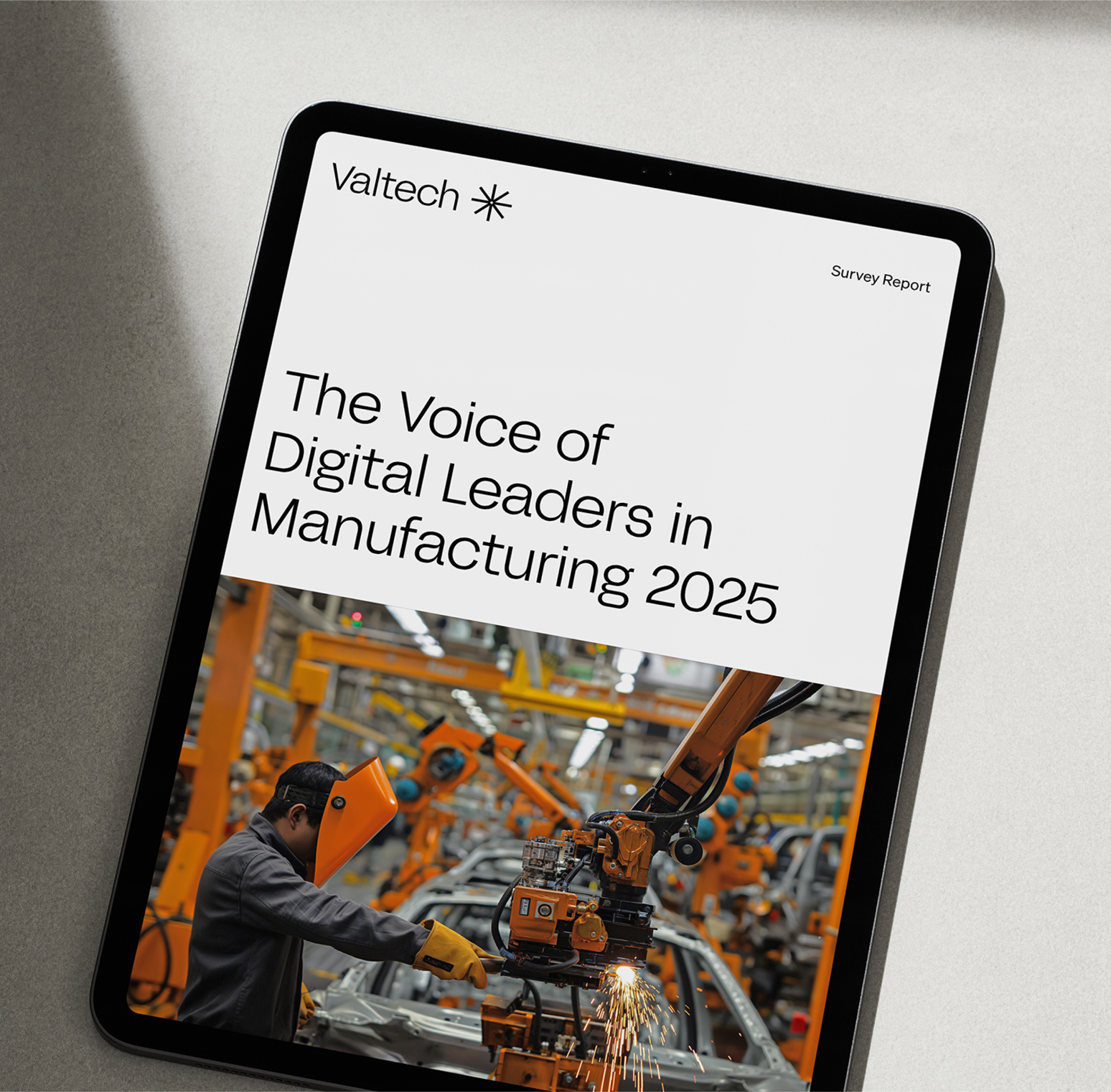 Tablet showing Valtech survey report: The Voice of Digital Leaders in Manufacturing, robotic arm.